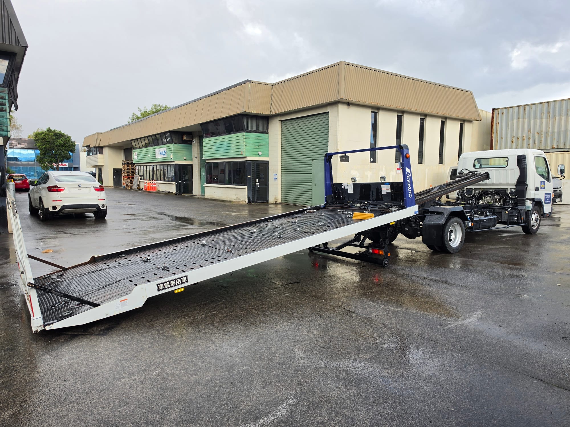 Flatbed tow truck with extended deck ready to load a vehicle in Auckland.